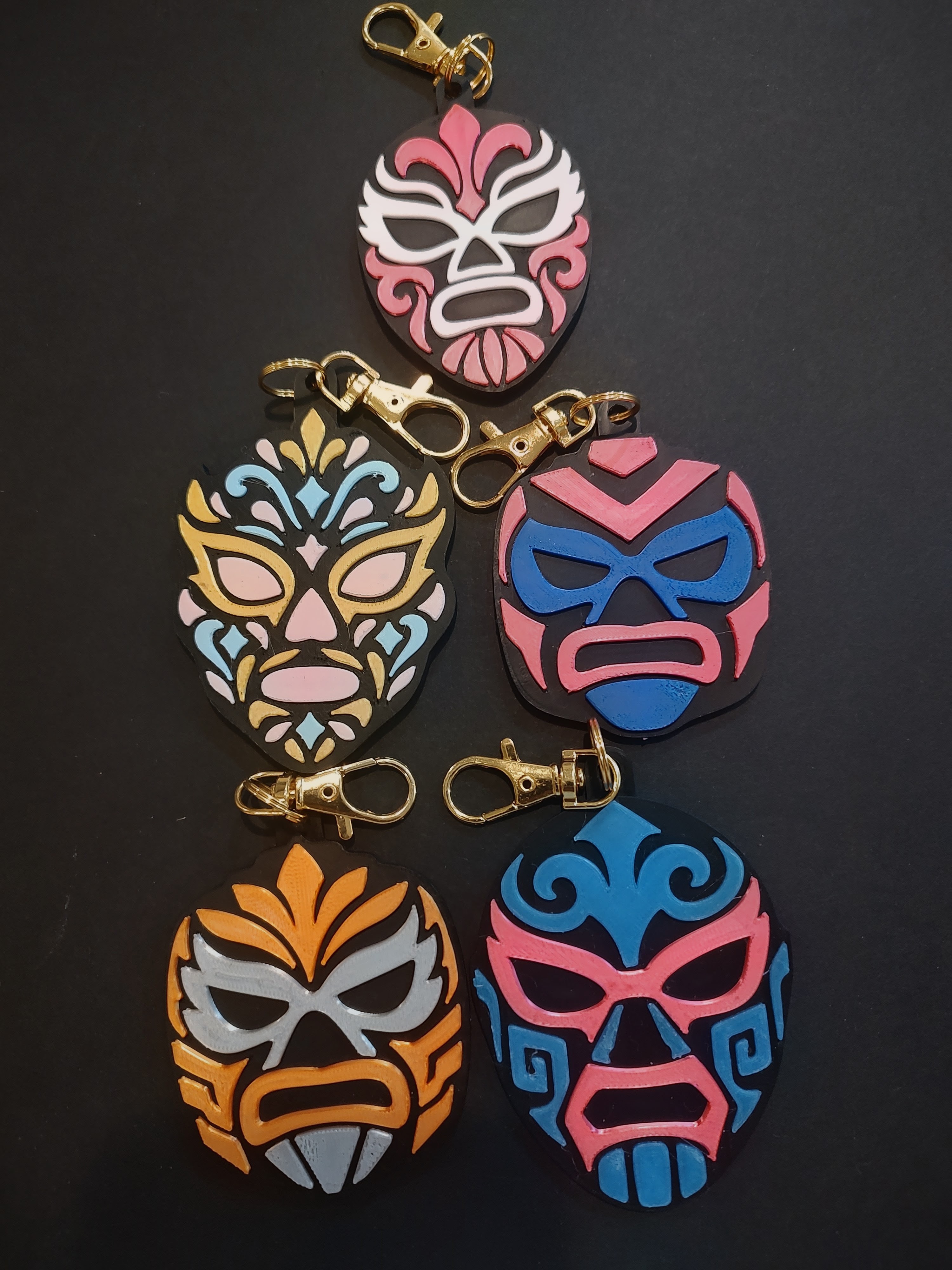 Five original MerchWT lucha mask bag charms in vivid colorways with gold clasps