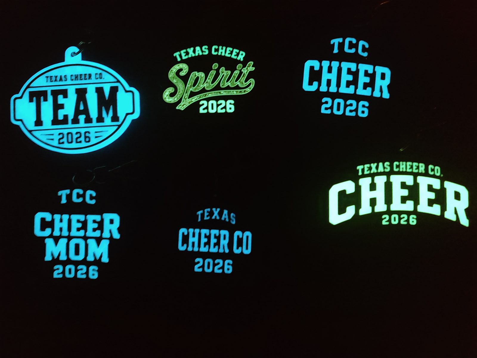 The same Texas Cheer Co. bag charms glowing in the dark
